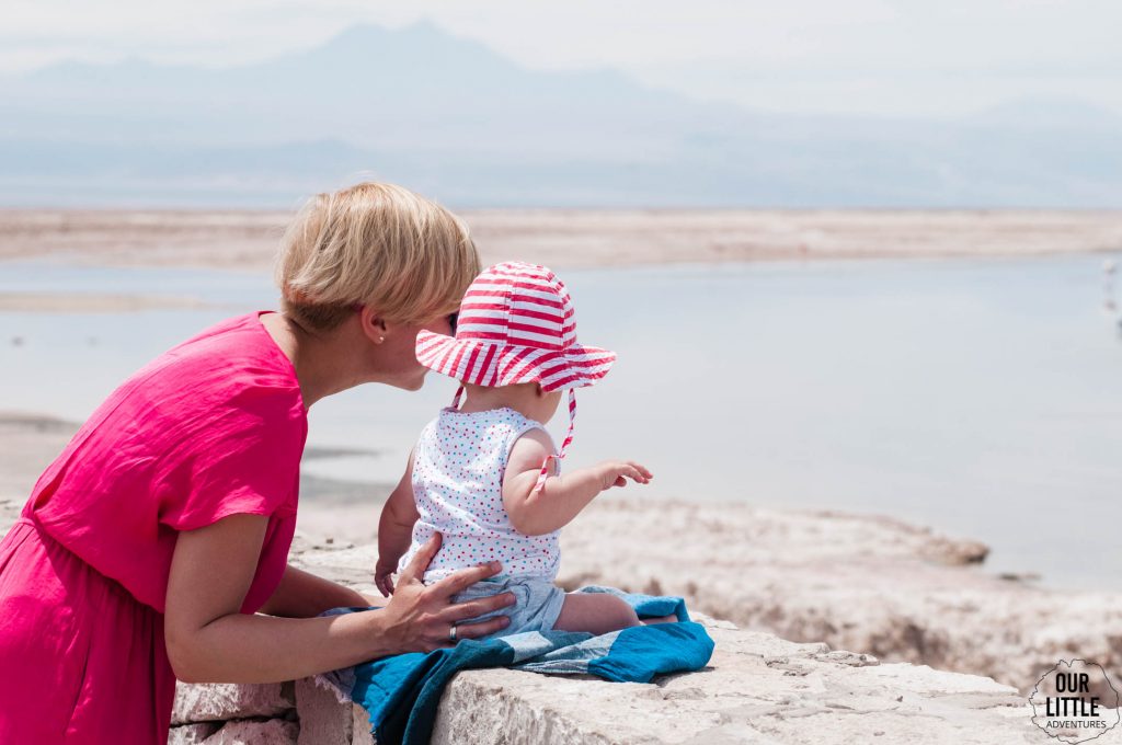 Kobieta z dzieckiem w Chile na Lagunie Chaxa obserwują flamingi