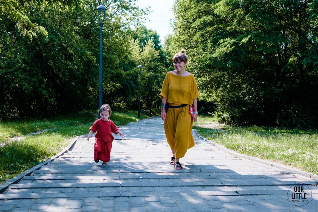 Kobieta spaceruje z dzieckiem, zdjęcie pochodzi z tekstu Chodź na spacer! O cudownym wpływie aktywności fizycznej na zdrowie
z bloga OurLittleAdventures.pl