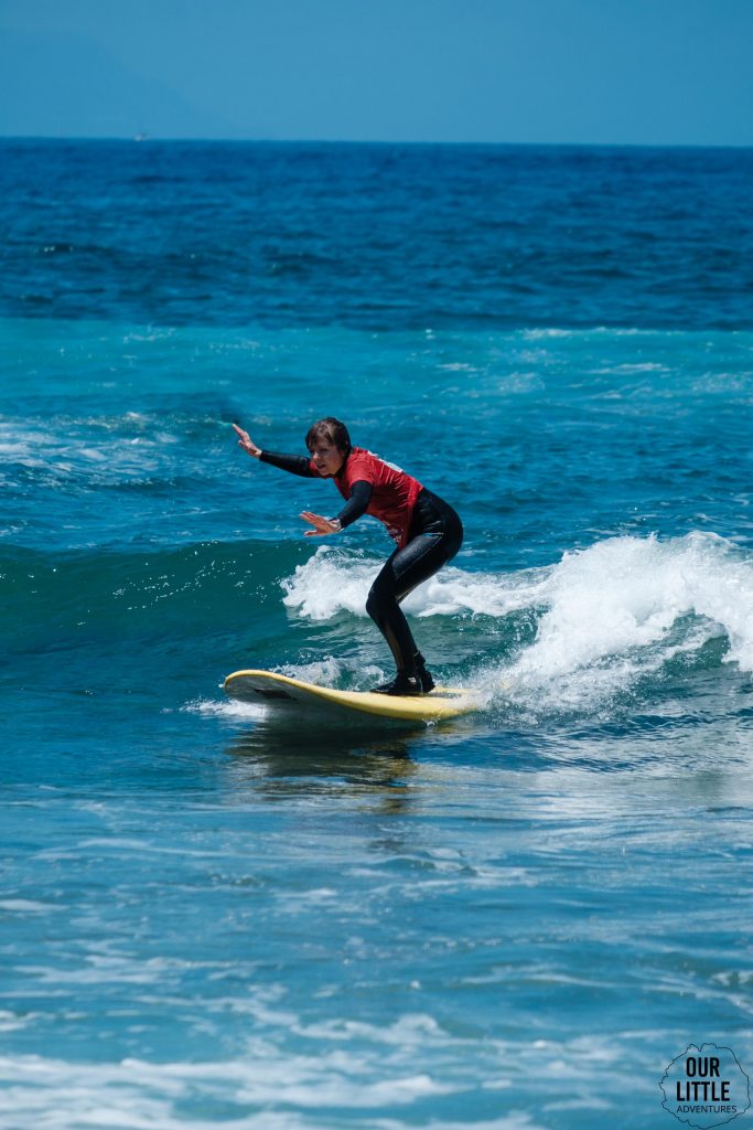 Kobieta uczy się na desce surfingowej na Teneryfie