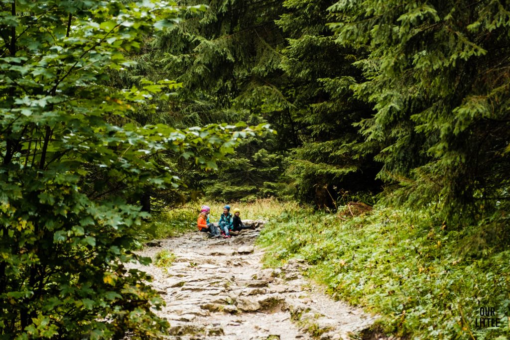Dzieci siedzące na szlaku w Dolinie Jaworzynka, zdjęcie autorstwa OurLittleAdventures.pl
