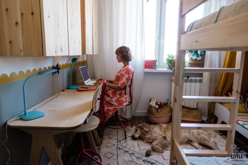 Kobieta siedzi przy biurku w pokoju dzieci, fot. OurLittleAdventures