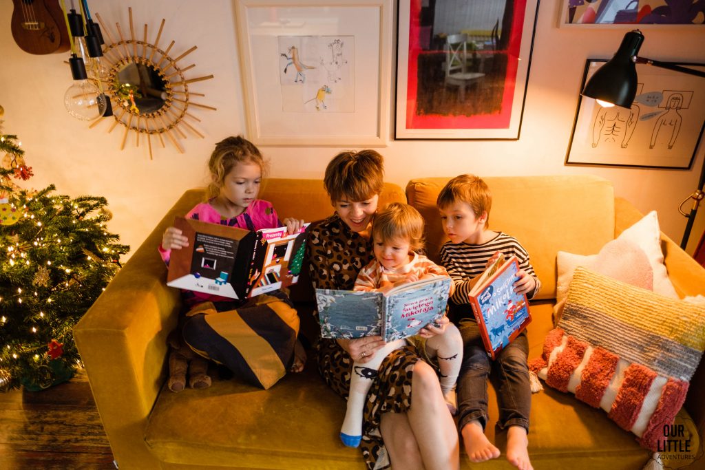 Dzieci czytają z Mamą książki na kanapie, świąteczna atmosfera, fot. OurLittleAdventures.pl