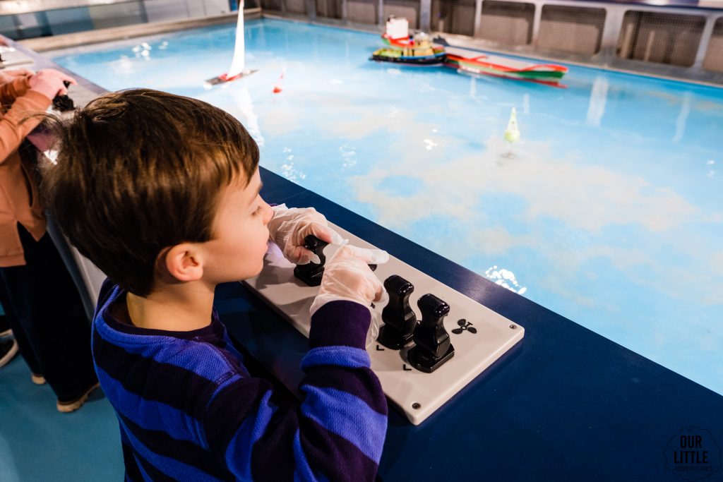 Chłopiec steruje statkiem w Ośrodku Kultury Morskiej w Gdańsku, zdjęcie autorstwa Our Little Adventures