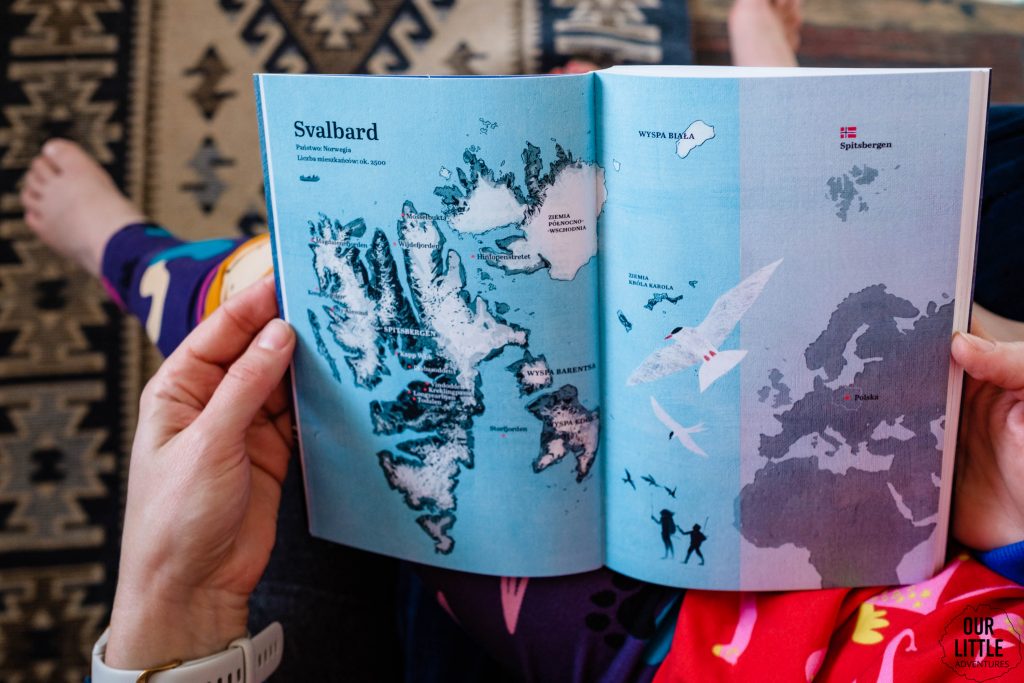 Książka Przyjaciel północy trzymana na kolanach przez kobietę i dziecko, rozkładówka z mapą Svalbard, zdjęcie autorstwa OurLittleAdventures.pl - - książki przygodowe dla dzieci