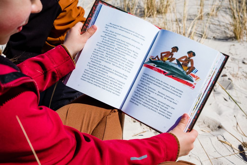Dzieci czytają książkę Jadą Haliki przez Ameryki Mirosława Wlekłego, zdjęcie autorstwa OurLittleAdventures.pl