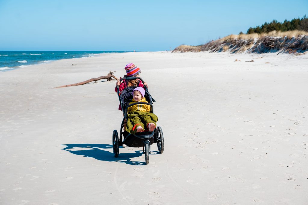 Dziecko w wózku na plaży w Lubiatowie, zdjęcie autorstwa OurLittleAdventures.pl
