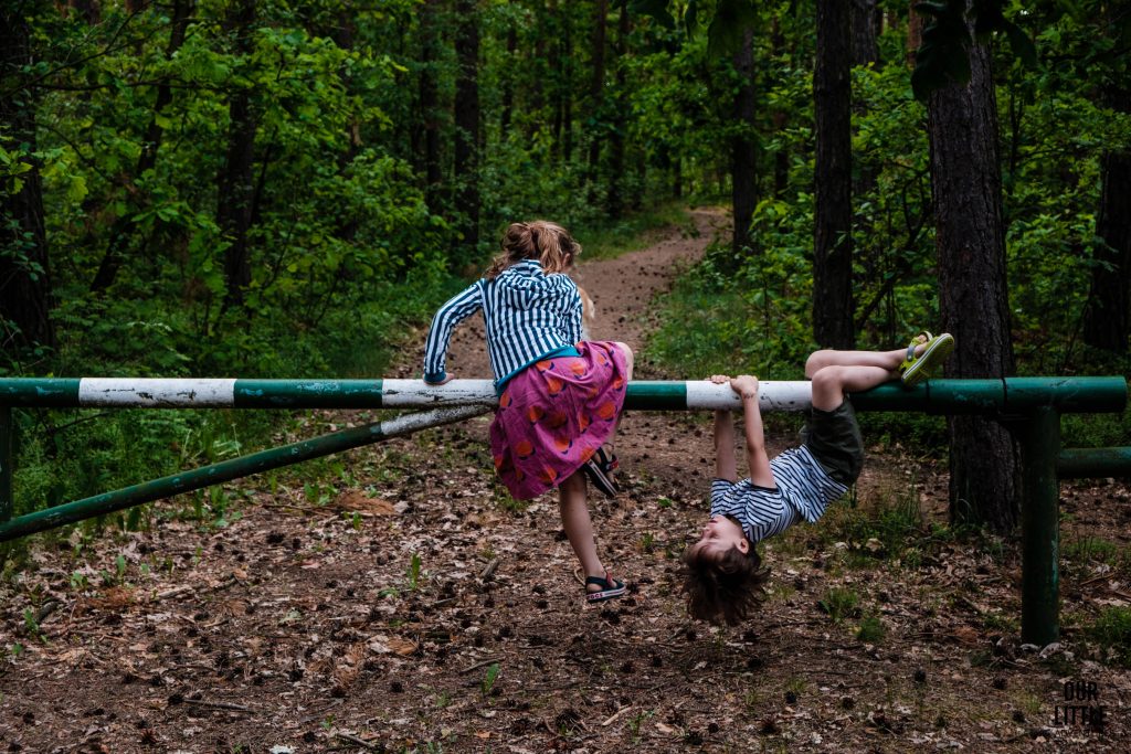 Dzieci bawią się na leśnym szlabanie, Bezpieczne wakacje z dziećmi, zdjęcie autorstwa OurLittleAdventures.pl