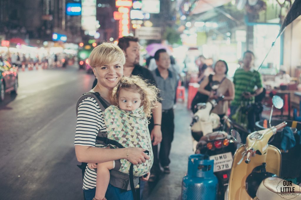 Kobieta z dzieckiem w nosidle na ulicy w Bangkoku, tekst: Przeprowadzka do Tajlandii, zdjęcie autorstwa OurLittleAdventures.pl