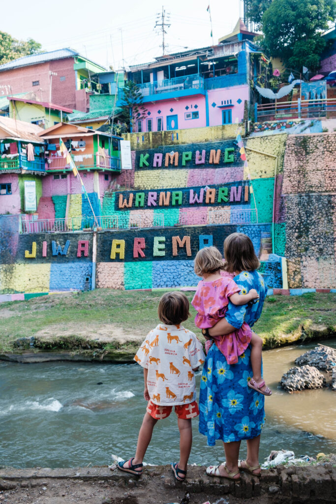 Dzieci stoją na tle trójwumiarowego muralu w na Jodipan na Jawie, Indoenzja, zdjęcie pochodzi z tekstu Jodipan - niezwykła kolorowa dzielnica Malangu, blog OurLittleAdventures.pl