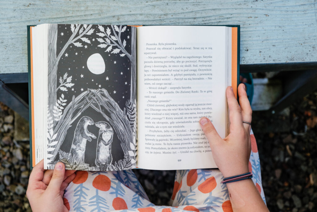 Dziecko trzyma książkę Opowieść z Zielonej Rzeki, Holly Webb, wydawnictwo Świetlik, fot. OurLittleAdventures.pl
