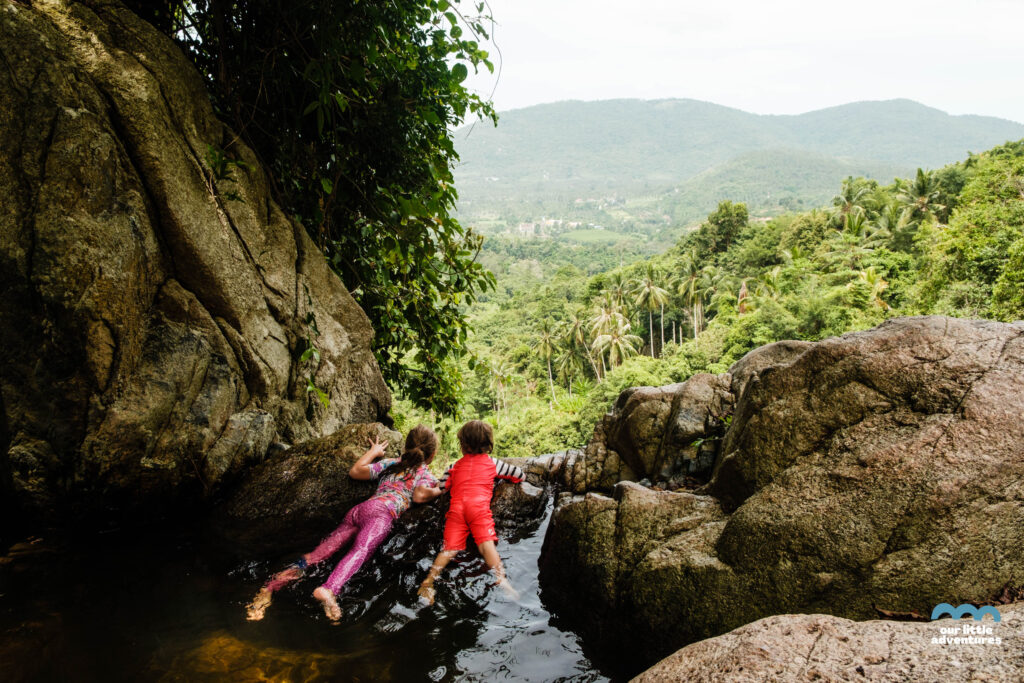 Dzieci siedzą w basenie na szczycie wodospadu Na Muang Waterfalls na wyspie Koh Samui w Tajlandii;  zdjęcie pochodzi z tekstu Koh Samui co warto zobaczyć - 5 miejsc, tekst z bloga Ourlittleadventures.pl
