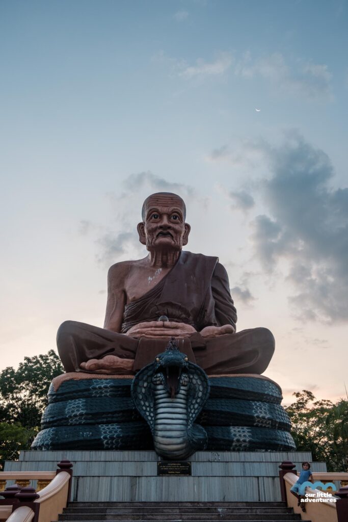 ogromny budda siedzący na wężu przed wejściem do świątyni Wat Bang Thong
