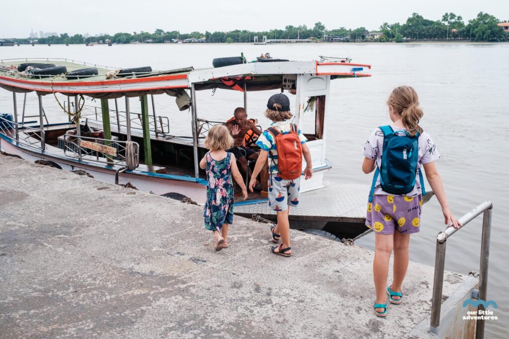 Dzieci wsiadające na łódkę w Azji - zdjęcie pochodzi z tekstu na blogu OurLittleAdventures.pl pt. Wyspa Bang Krachao - wycieczka rowerowa z dziećmi do zielonej oazy Bangkoku