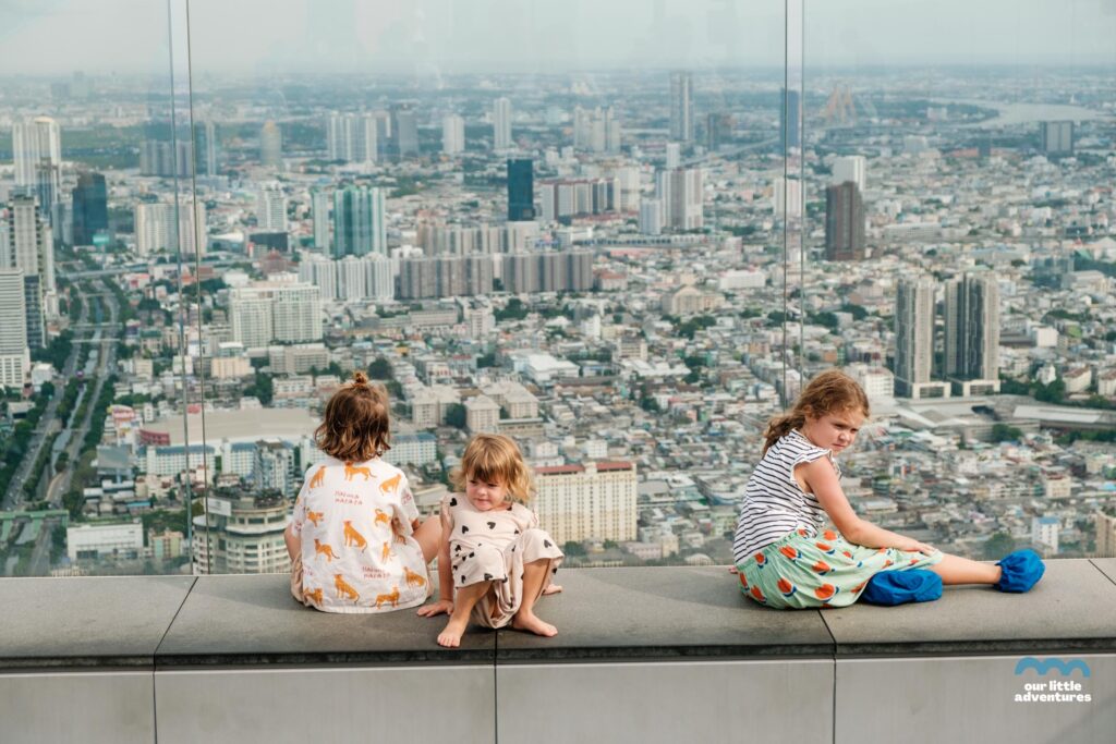 Dzieci siedzą na tarasie widokowym Sky Walk w Bangkoku, King Power Mahanakh, najwyższy budynek Tajlandii, fot. OurLittleAdventures.pl
