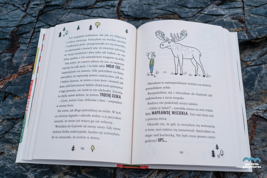 Zdjęcie strony z książki Gaja z Gajówki. Chatka w sercu lasu Anny Włodarkiewicz (wyd. Świetlik) stoi opartyy o drzewo, zdjęcie autorstwa OurLittleAdventures.pl
