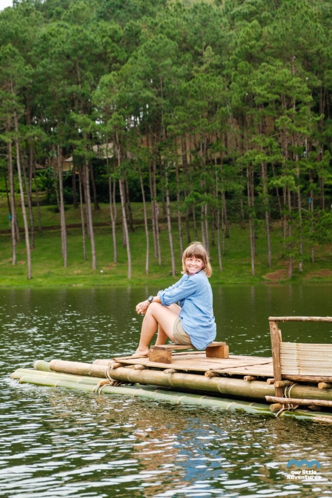 kobieta na bambusowiej tratwie na jeziorze w królewskim parku Pang Oung